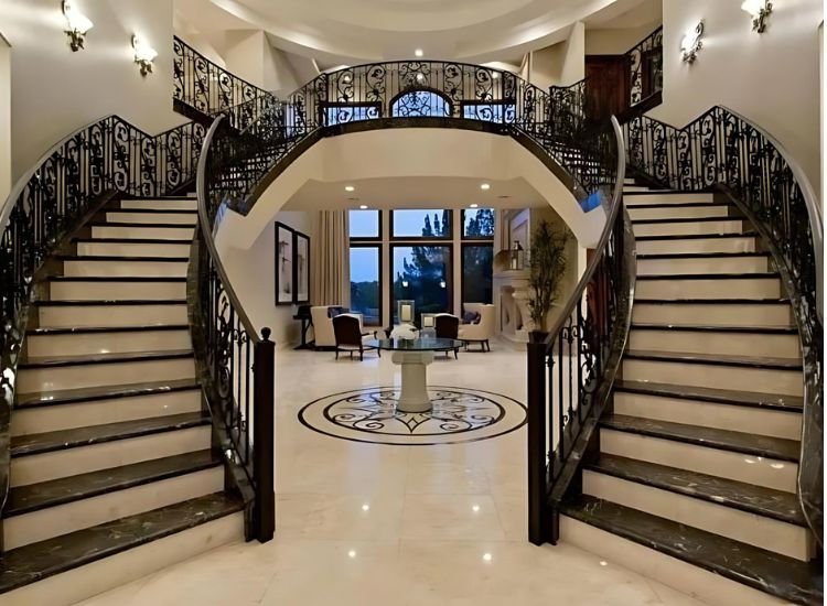 Luxurious bifurcated stairs with elegant railings and rich materials, creating a stunning focal point in an upscale interior.