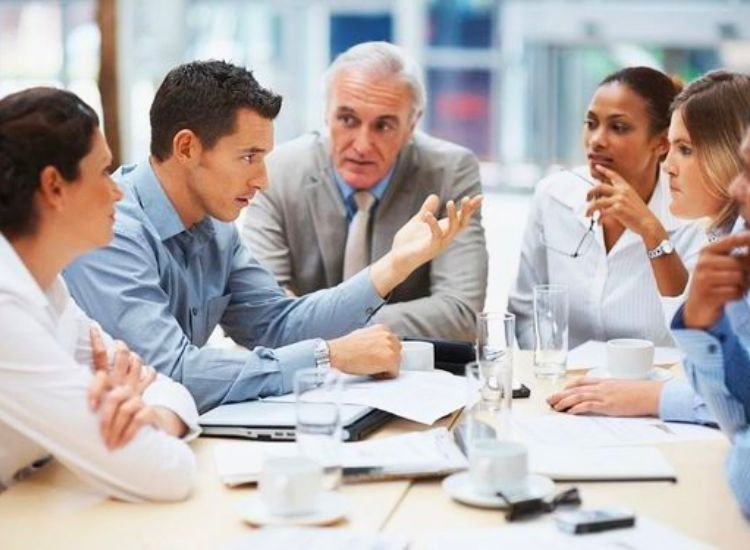 A group of people engaged in a discussion on a specific topic, working to negotiate and resolve a heated debate through conversation.