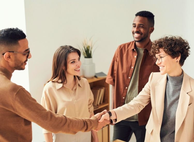 A mediator resolving legal issues between two people, who are then seen reaching a deal and shaking hands to finalize the agreement.