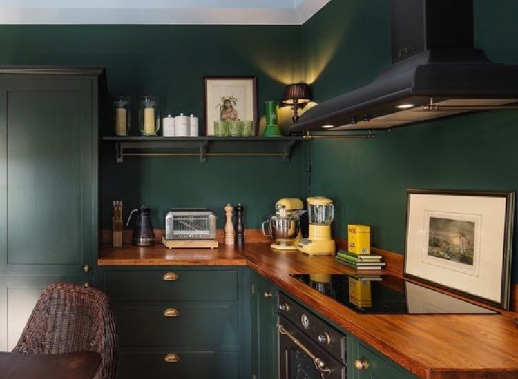 Emerald green kitchen walls creating a luxurious and rich atmosphere, enhancing the design with elegance and depth.