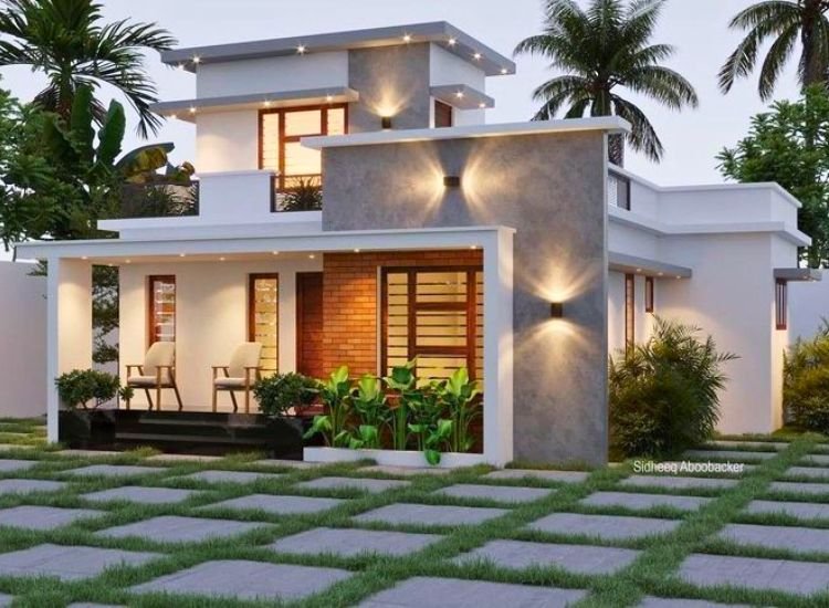 A simple home with ample yard space and beautiful finishing, complemented by stylish exterior wall sconces and lush greenery.