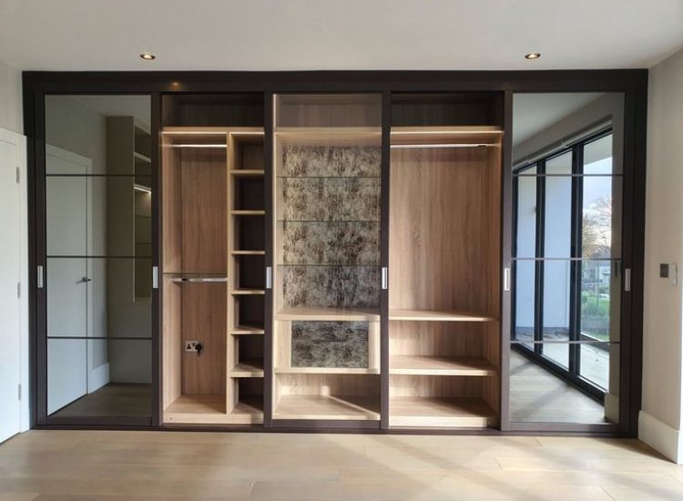 Sliding door reach-in wardrobe in plywood and glass, offering a modern blend of materials for stylish storage and easy access in compact spaces.