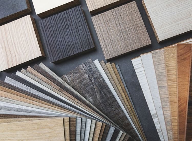 Assorted laminate sheets displayed on a table, showcasing a range of colors and textures for interior design options.