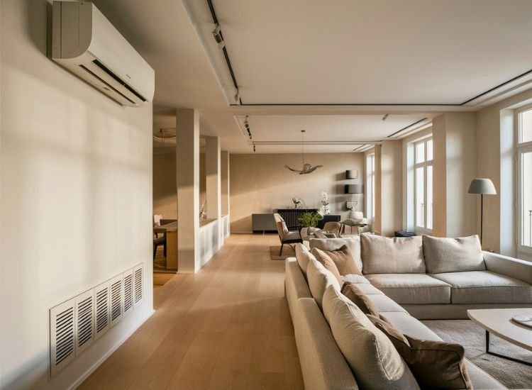 Living room fully finished with HVAC system, featuring wall-mounted A/C and large windows that provide ample air and sunlight, creating a bright and comfortable space.