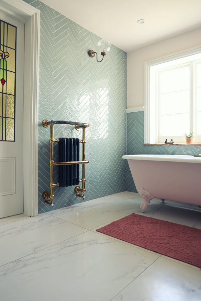 A bathroom with a pink bathtub and porcelain tiles, offering a serene and colorful space for relaxation