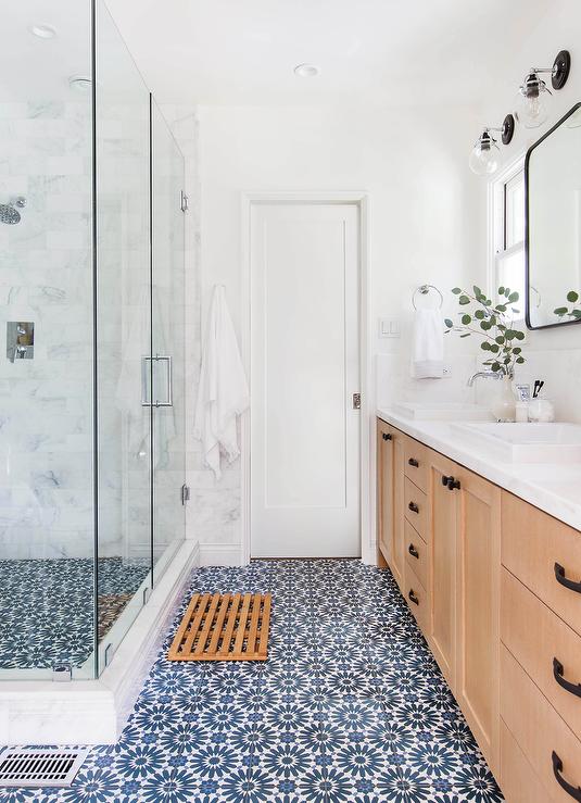 A bathroom with an elegant blue and white mosaic tile floor, providing a sleek and modern look to the space