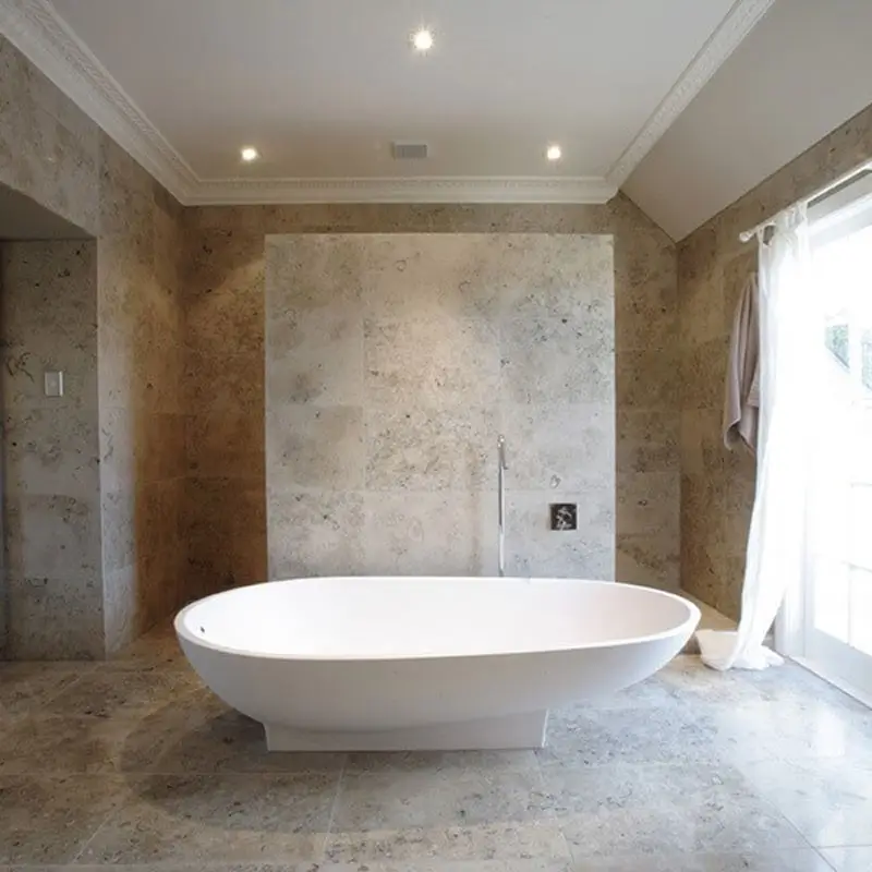 A spacious bathroom designed with natural limestone tiles offering a timeless and classic look to the bathroom