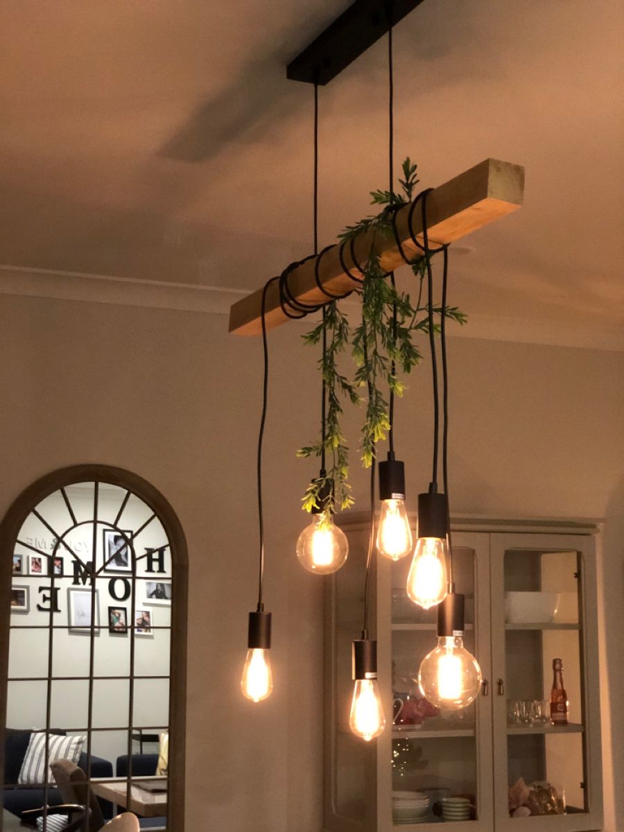 A warm, cozy, artificial decorative light fixture adorned with plants and bulbs, creating the desired atmosphere