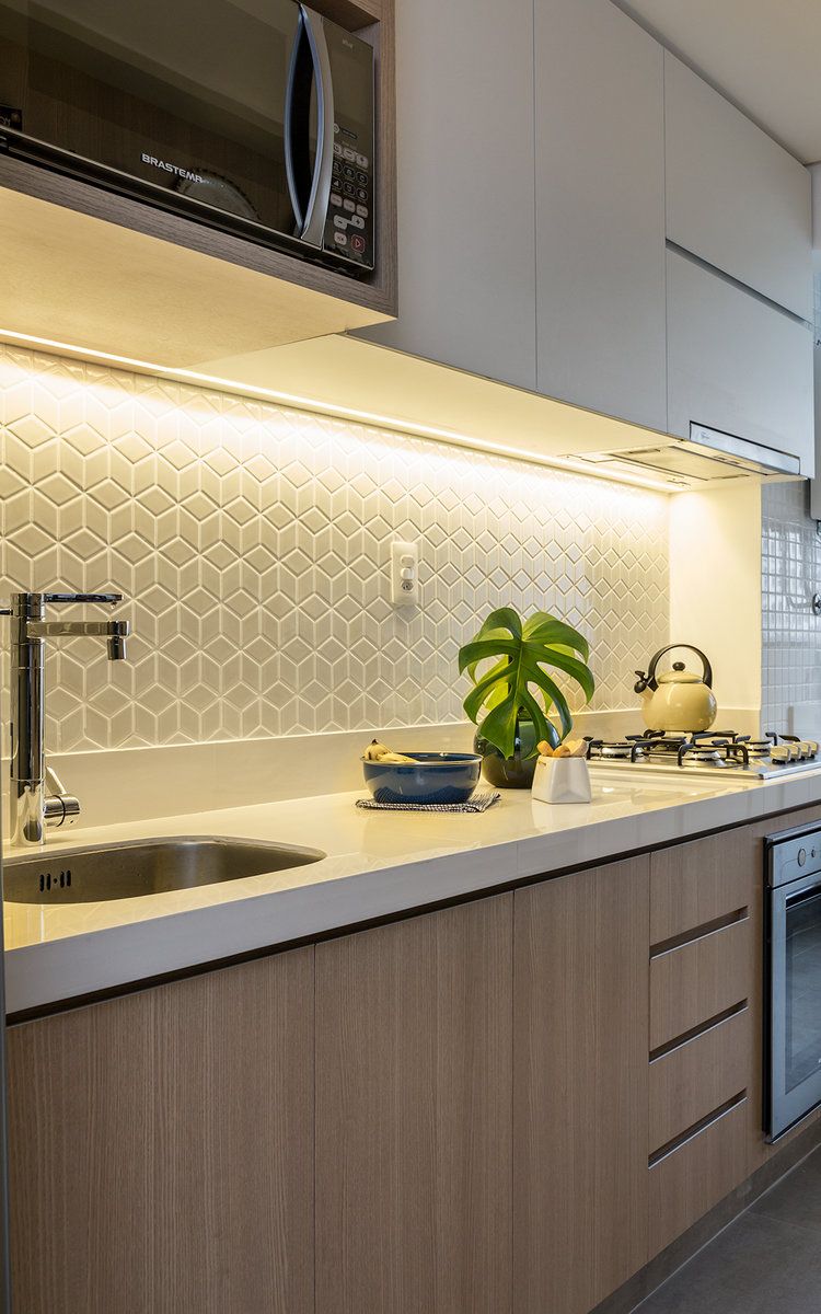 A well-equipped kitchen featuring a white countertop and under cabinet task lighting providing focused light for working