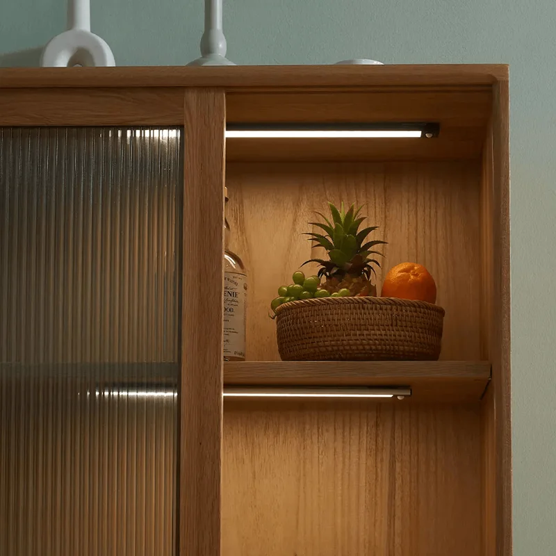 A wooden storage cabinet with profile lights illuminating the area, adding a warm and inviting ambiance