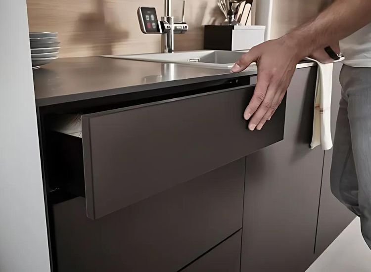 A man opening a kitchen drawer, revealing neatly organized utensils, in a kitchen with Anti-Fingerprint Laminate