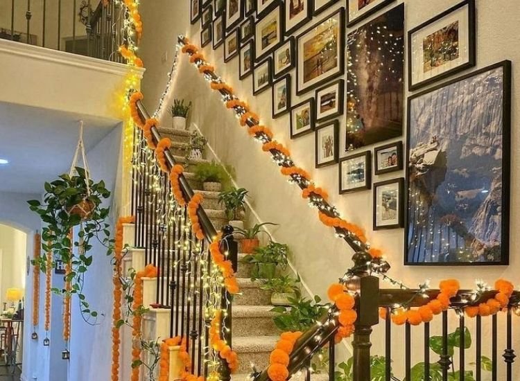 "Warm Diwali lighting images of glowing diyas placed around a staircase decoration with festive floral decorations."