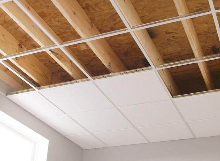 Ceiling with wooden beams and white trim, showcasing structural plywood