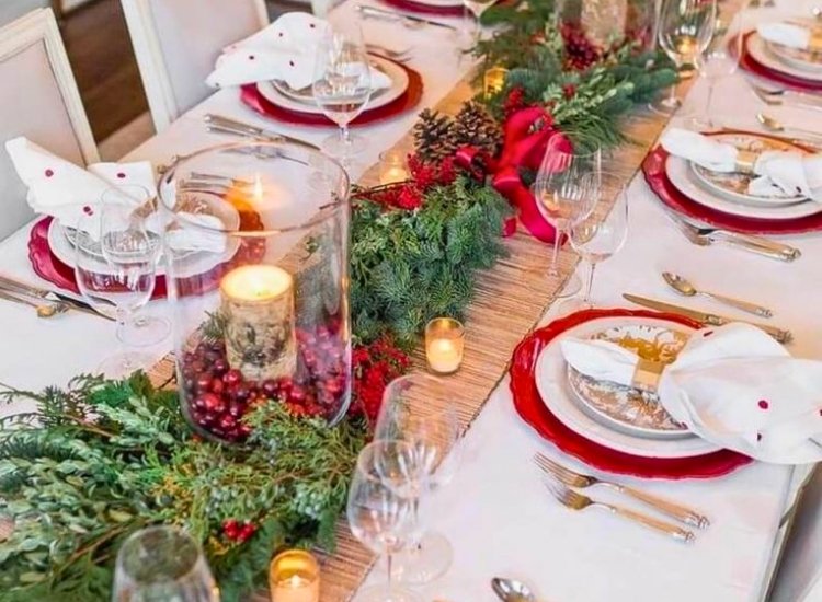 "Christmas-themed napkin rings and plates add festive elegance to the table. christmas tree picture shines in the background."