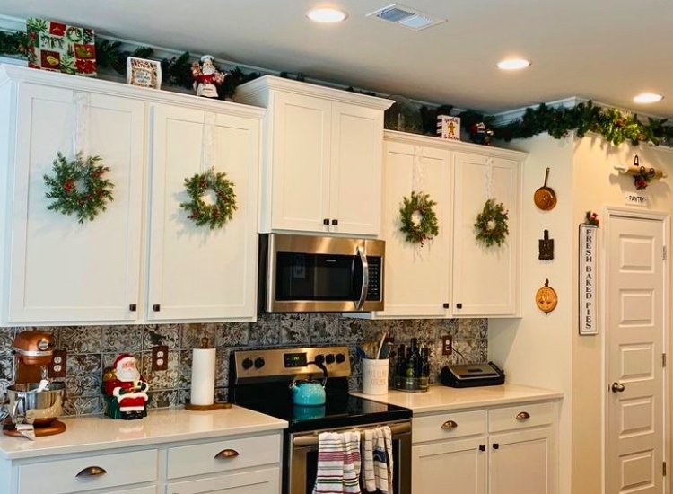 "Small wreaths on cabinet doors add a festive touch. christmas tree picture completes the holiday look."