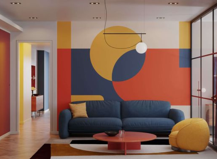 Differently shaped wallpaper in yellow, red, and navy blue, paired with matching sofas, create a striking contrast and dynamic visual interest in the room.